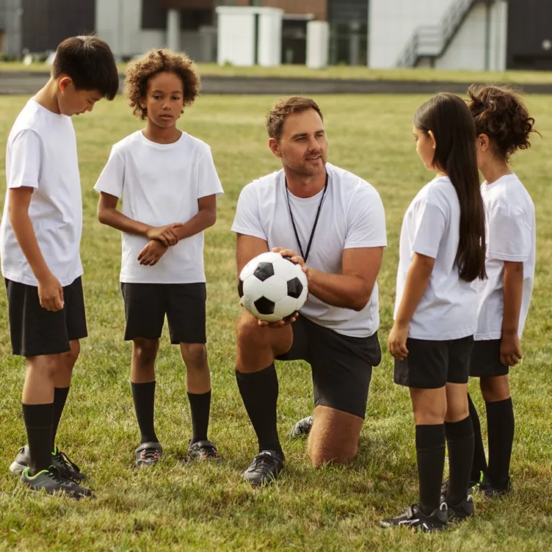 Il mister con il pallone spiega ai ragazzi